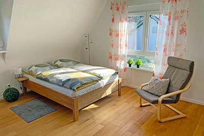 Schlafzimmer mit Doppelbett und Sitzgelegenheit