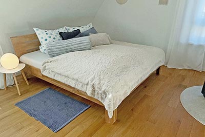 Zweites Schlafzimmer mit Doppelbett und bequemem Sessel