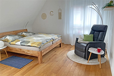 Zweites Schlafzimmer mit Doppelbett und bequemem Sessel