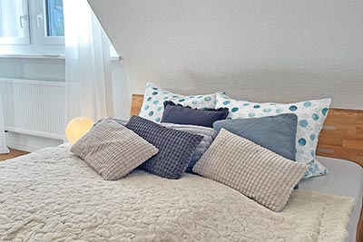 Zweites Schlafzimmer mit Doppelbett und bequemem Sessel